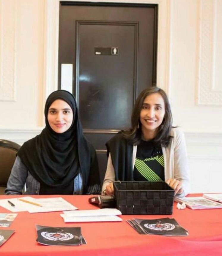 Naila with residents and partners at an event table